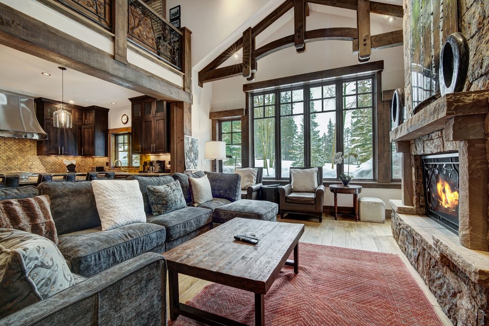 This is a photo of the living area with a view of the kitchen in the background