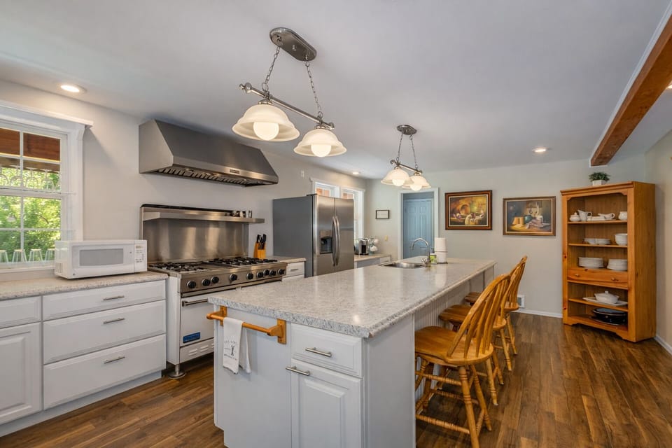 Your fully equipped chef's kitchen awaits with granite counters, professional appliances, and a spacious island for memorable meal preparation together.