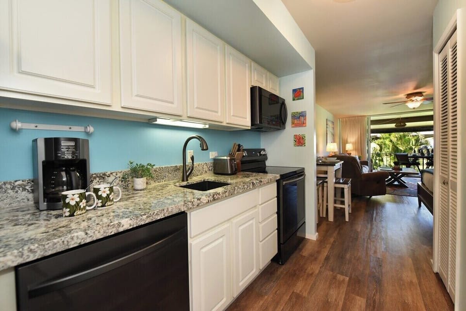 A fully equipped kitchen featuring granite countertops, sleek cabinetry, and modern appliances