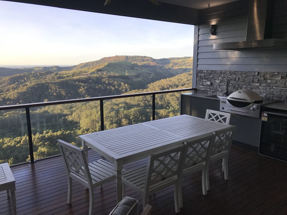 Outdoor kitchen with BBQ, sink, fridge and dining 