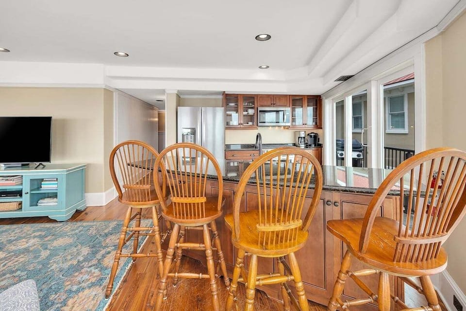 Dining area with wood chairs, teal console, adjacent kitchen