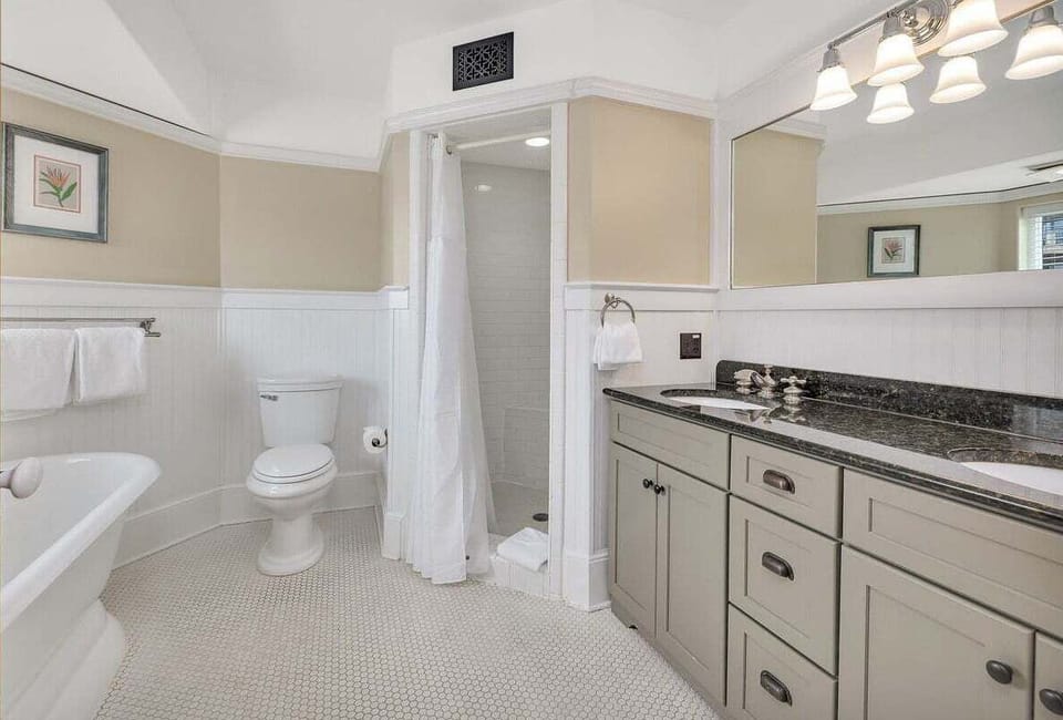 Bathroom with dark granite vanity, tub, shower, and mosaic tile floor