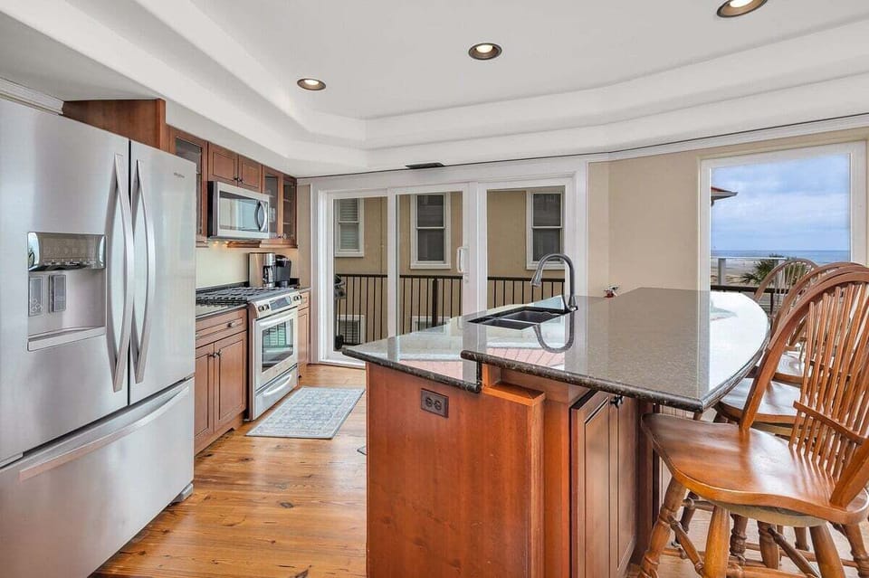 Kitchen with stainless appliances, dark granite island, wood floors