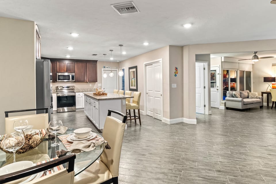 From the dining table, enjoy a full view of the bright kitchen and cozy living area.