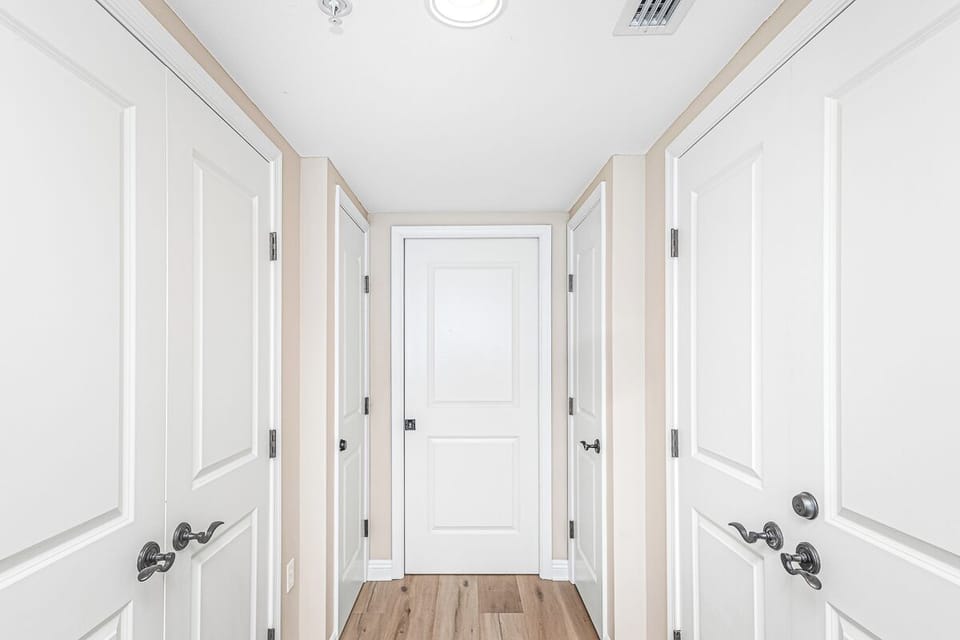 Step into your private hallway where clean lines and warm wood floors create a welcoming entrance to your comfortable retreat.