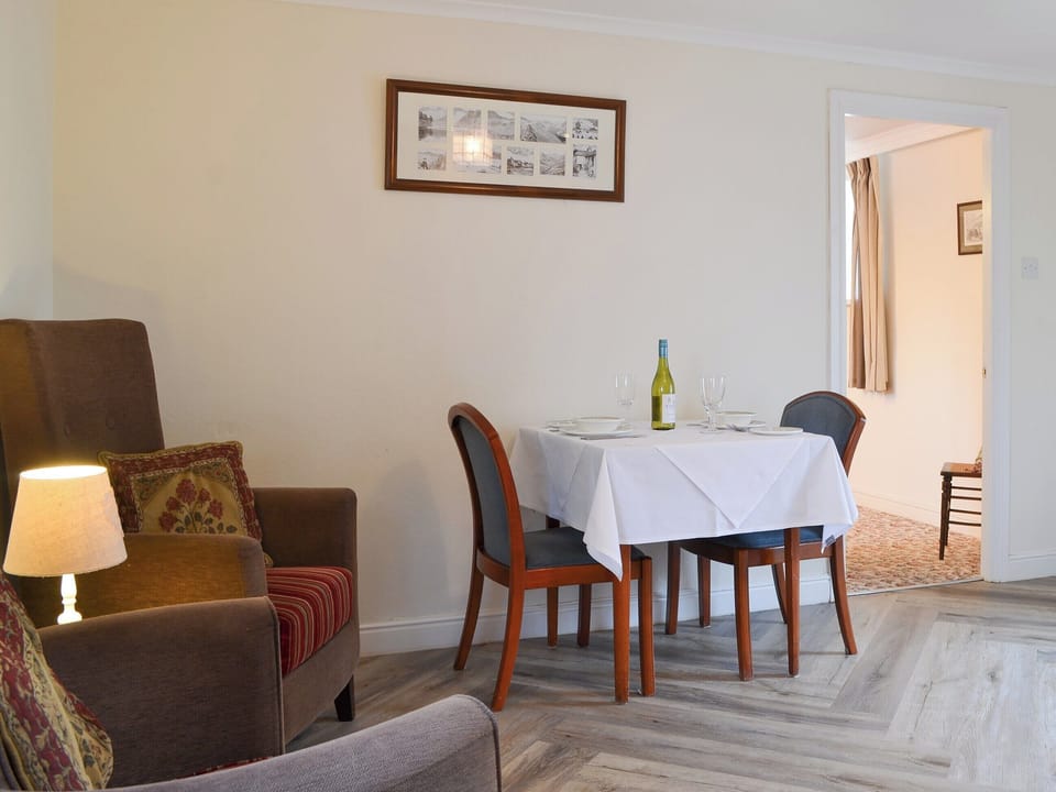 Compact dining area and comfortable armchairs | Lorna&rsquo;s At The Grange - Grange Country House Holiday Cottages, Loweswater, near Cockermouth