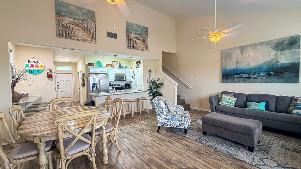 Relax in your spacious open-plan living area where ocean-inspired artwork and cozy furnishings create the perfect beach retreat atmosphere.