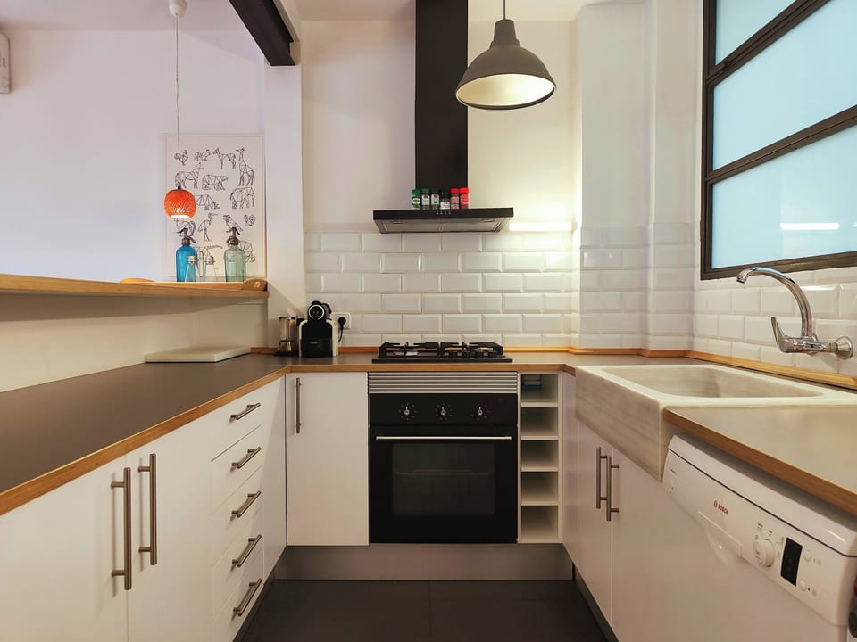 The open kitchen is fully equipped with modern appliances, including a gas hob, oven, and dishwasher, perfect for preparing meals.