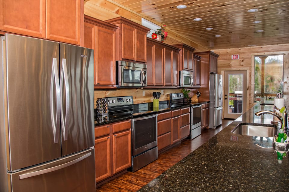 Kitchen with Two Refrigerators, Two Microwaves, and Two Stoves.