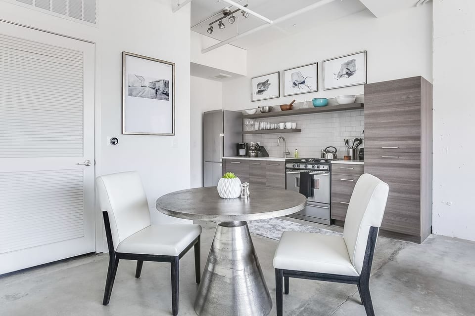 Dining area of this Apartment Near Ponce City Market, with the kitchen in the background.