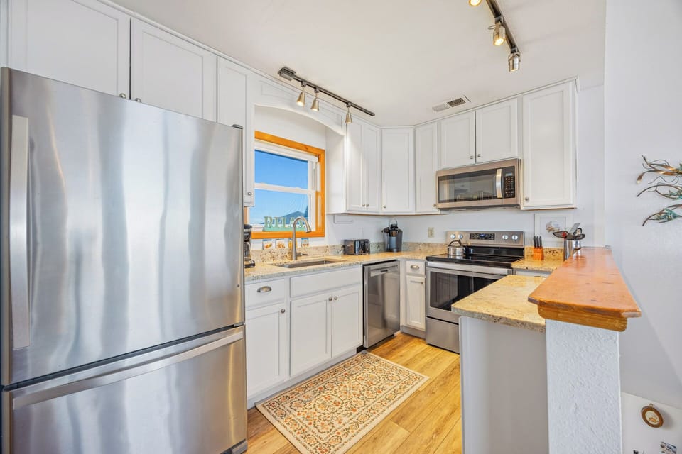 This bright kitchen offers everything you need for easy meal prep, with modern appliances, ample counter space, and a window framing lovely views to inspire your mornings.