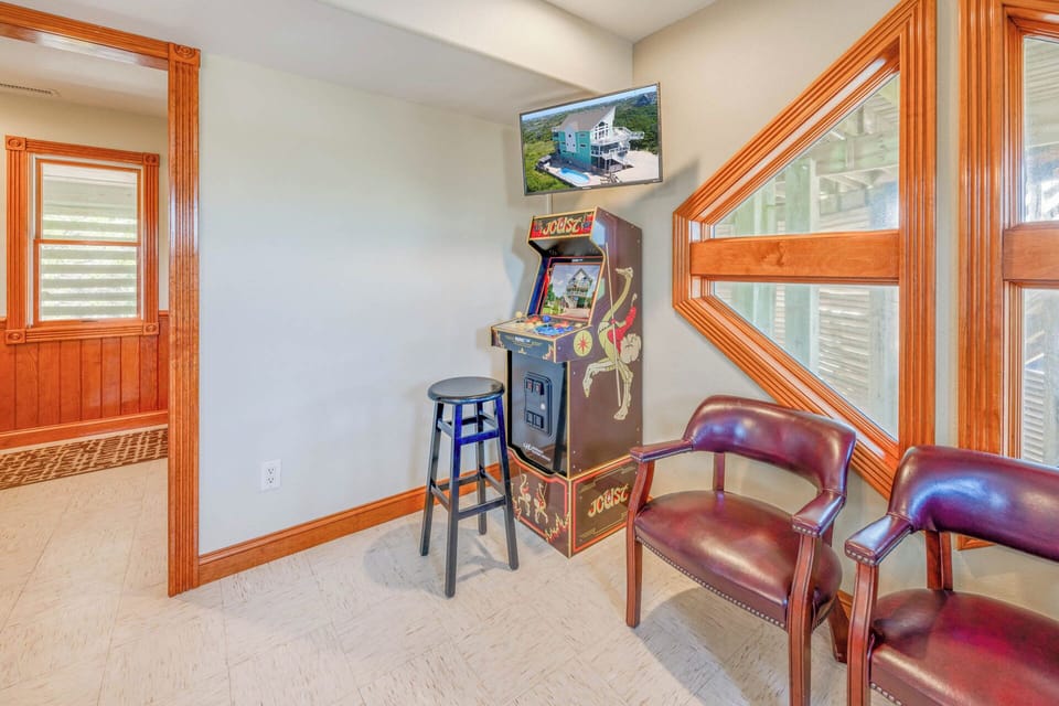 A standup arcade game console keeps the fun flowing in the game room.