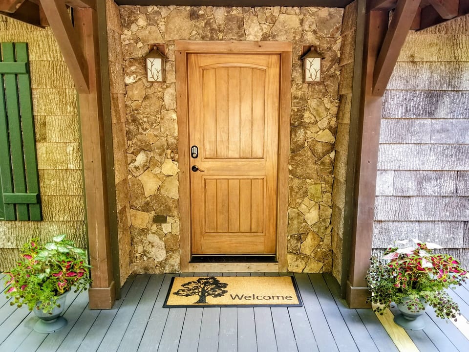 Covered front entry welcomes you to Blowing Rock Retreat with rustic stone accents and mountain cabin charm