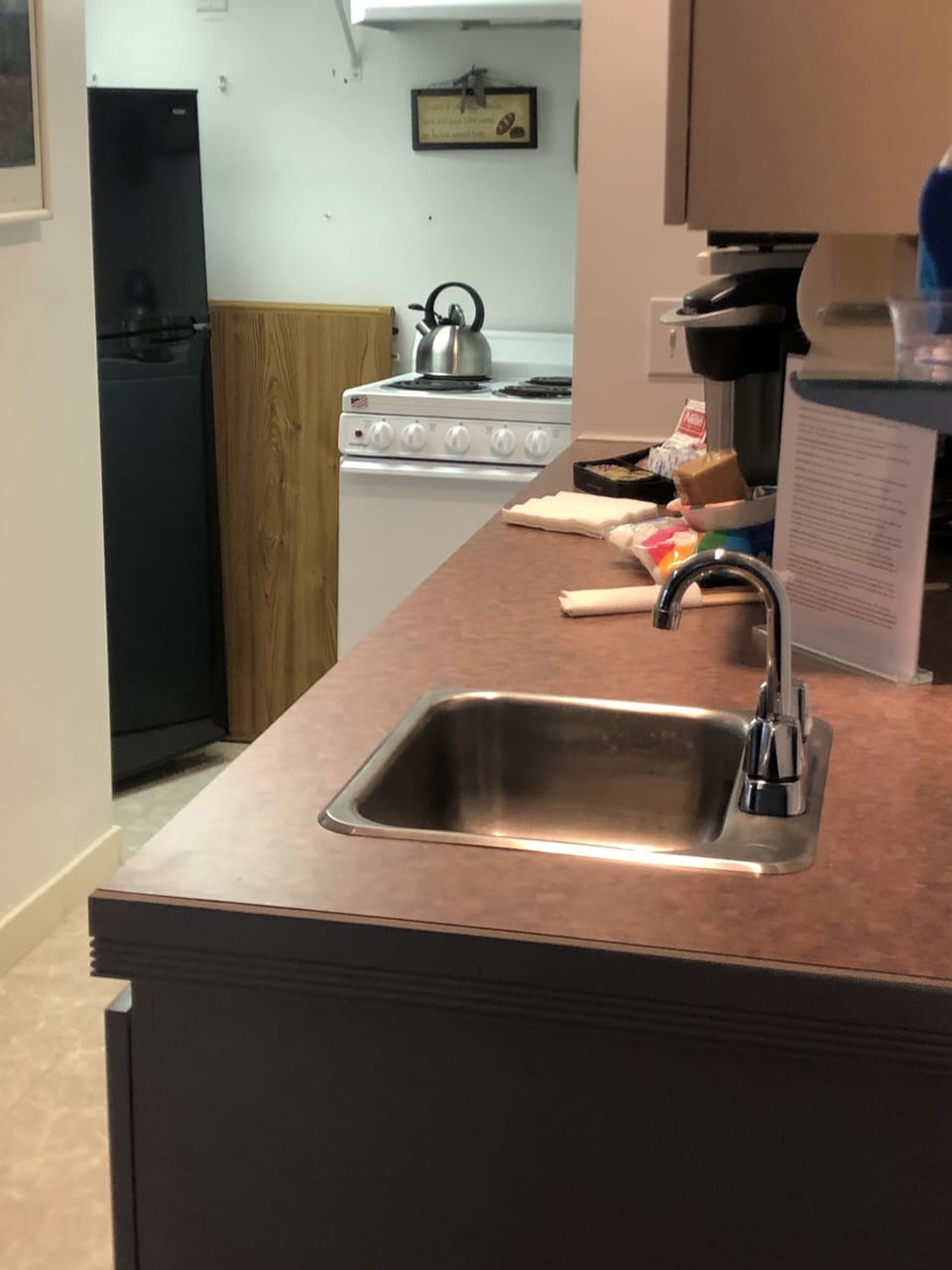 Small  kitchen, fridge, micro, toaster, keurig, stove, table leaf, small sink.