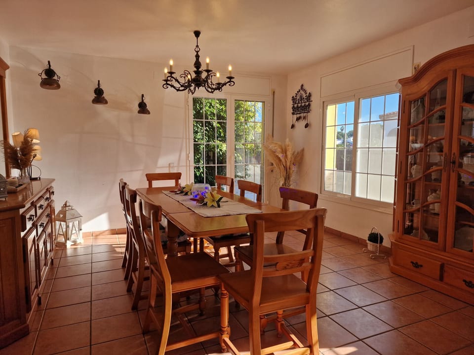 Dine with a beautiful view: The bright dining area at holiday home Eva offers convenient cabinets and looks straight out into the yard. Book now!