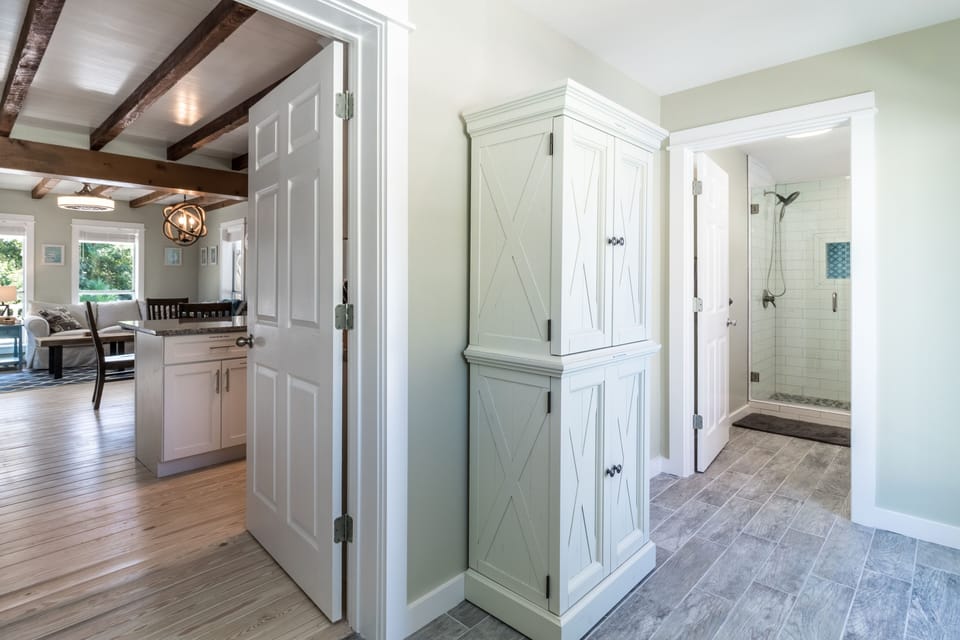 Upper cabinet holds pool towels and lower cabinet holds small kitchen appliances