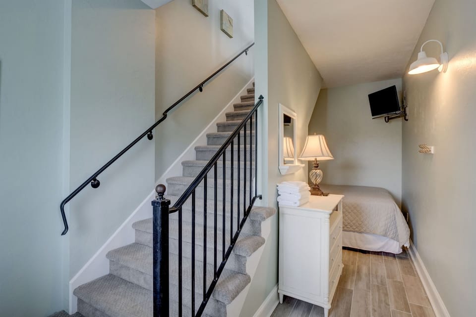 The ground floor Alcove has a queen bed tucked under the stairs and smart TV