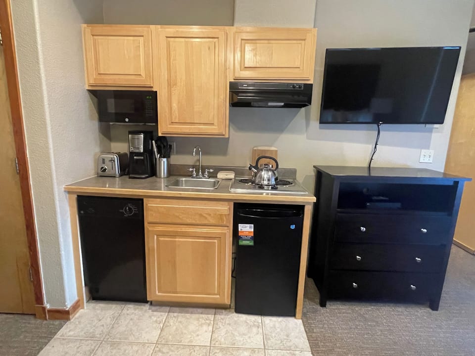 Kitchenette has utensils, cookware, and appliances.