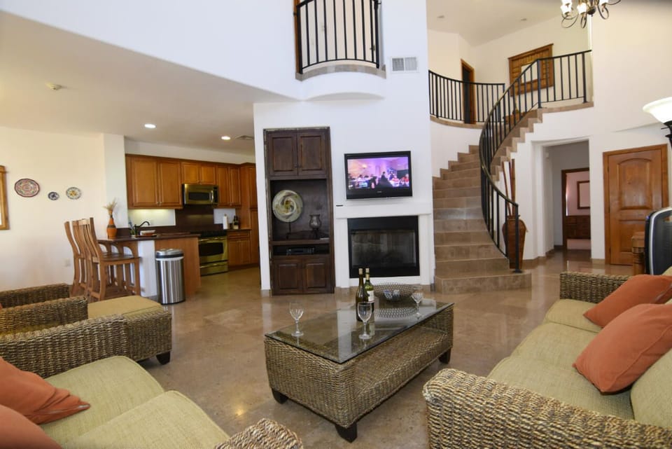 The downstairs living room features a flat screen TV mounted on the wall above a modern fireplace