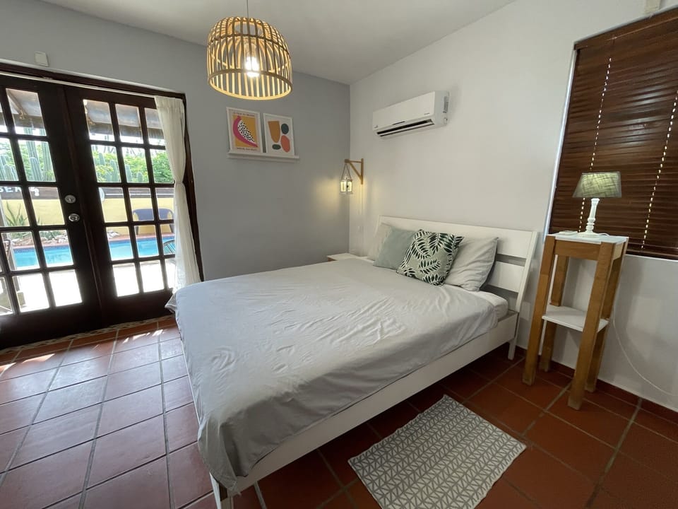 Master bedroom with double doors to the pool area