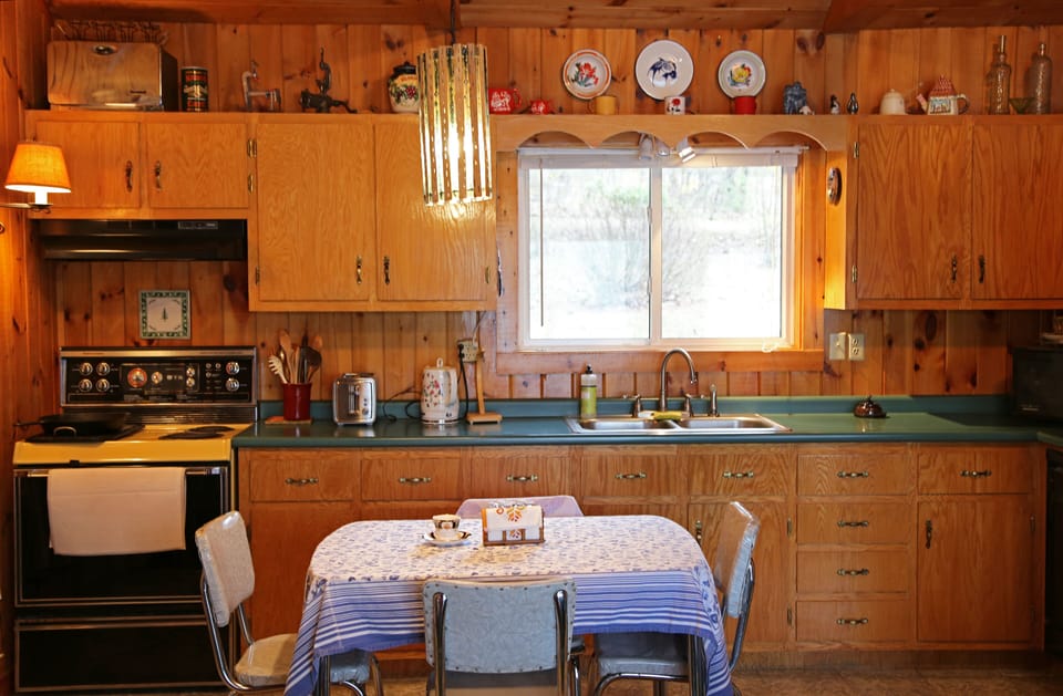 a full kitchen with stove, oven, fridge, microwave, toaster and teapot