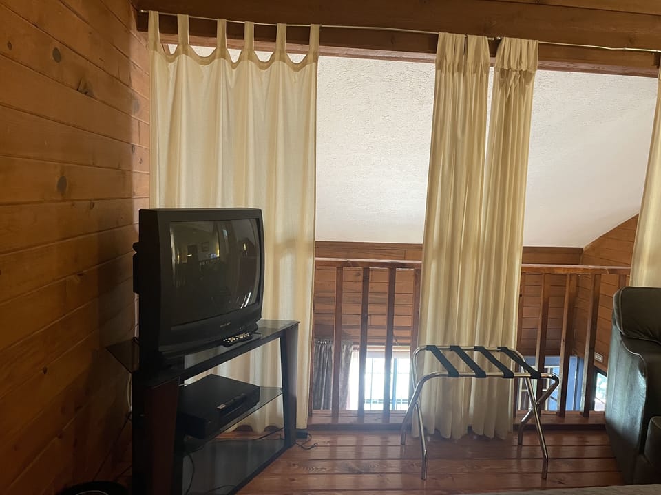 Upstairs loft bedroom has TV with cable and privacy curtains 