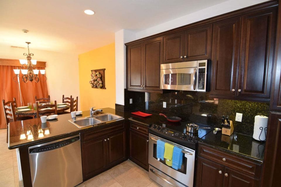 Fully equipped kitchen with refrigerator, stove, microwave, oven, and dishwasher — plus a coffee maker .