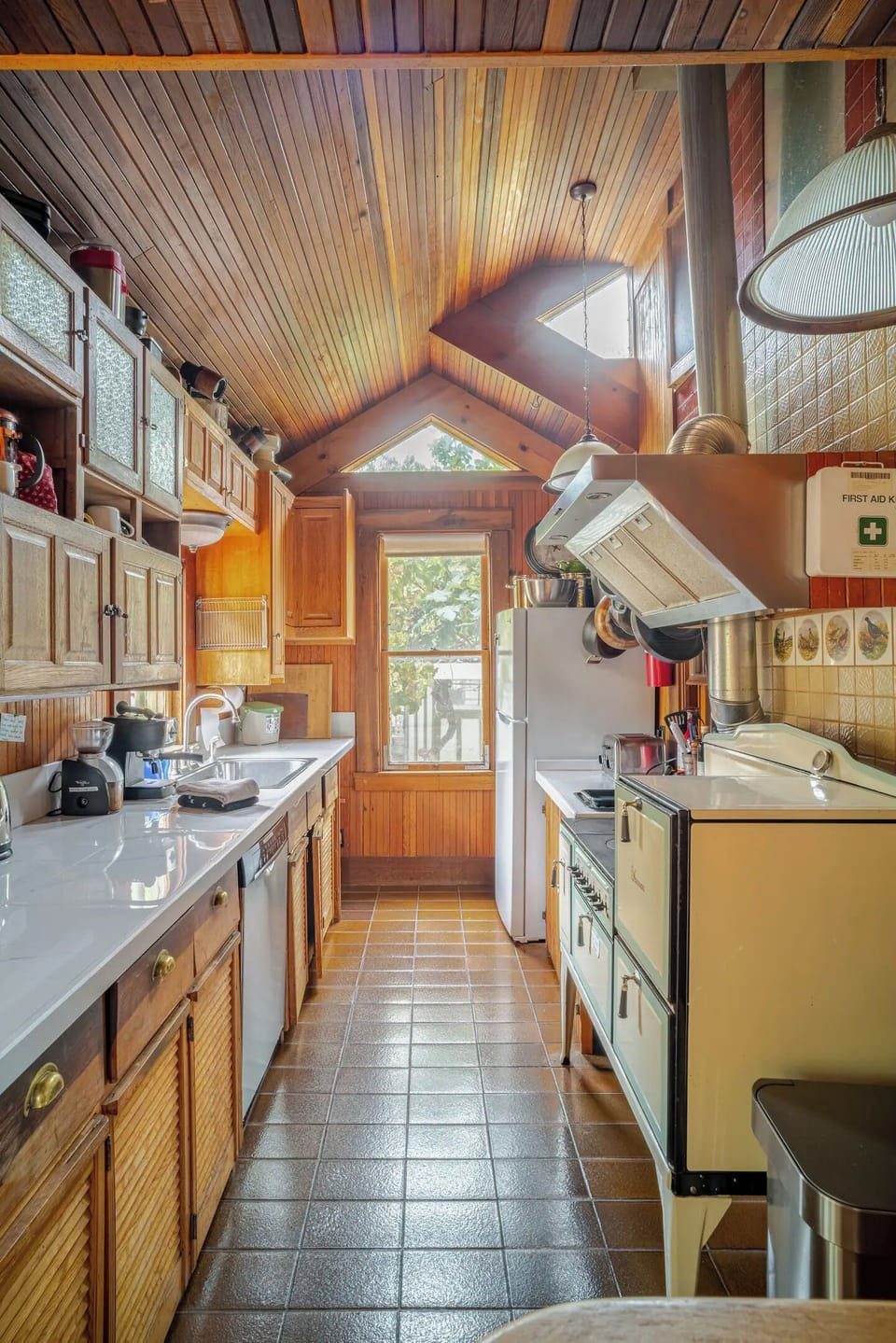 Kitchen counter and sink, refrigerator, stove and trash/recycling bin