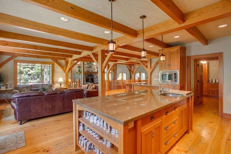 Open-concept timber lodge with gourmet island and cozy stone fireplace