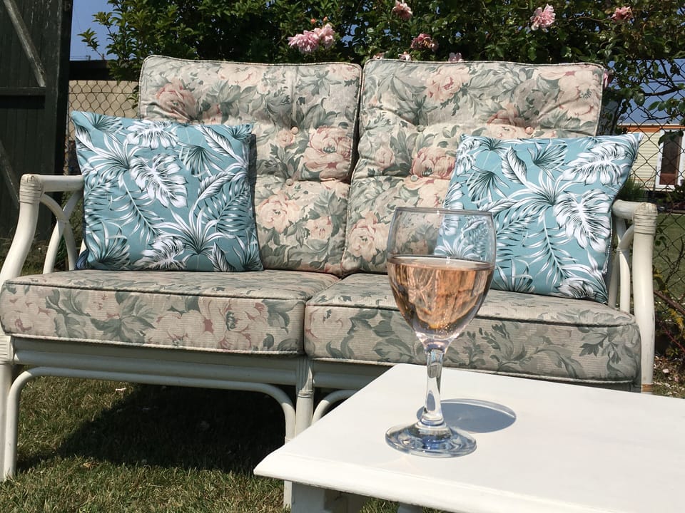Enjoy a glass of wine under the rose bush outside the summerhouse.