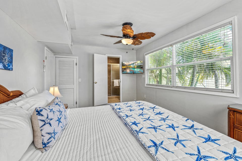 A king bed surrounded by beachy blues and natural light for peaceful mornings.