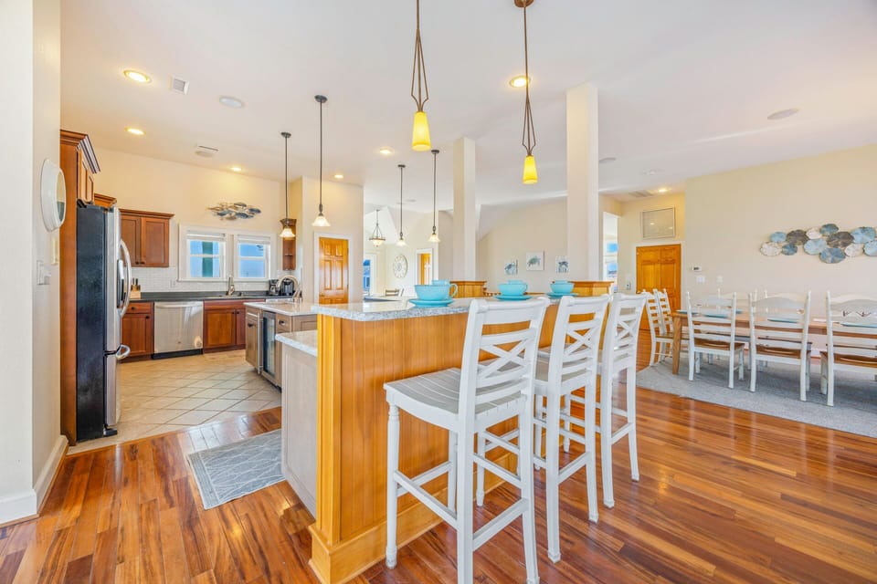 Your spacious kitchen flows seamlessly into the dining area, featuring granite countertops, stainless appliances, and a breakfast bar perfect for morning coffee.