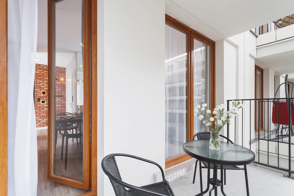 Furnished balcony with green surroundings. 
