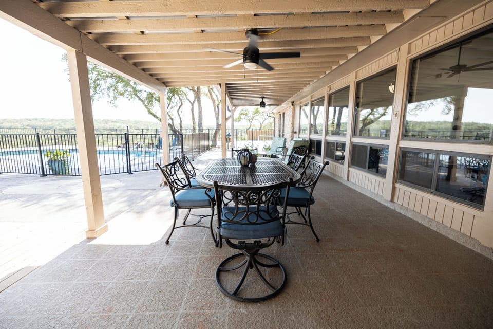 Outdoor covered porch with additional table and outdoor furniture.