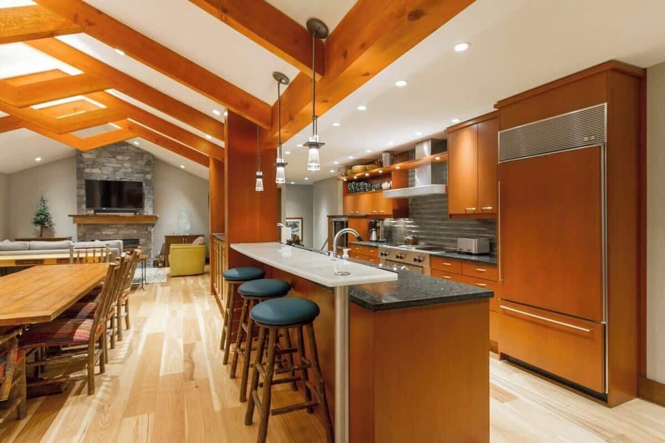 - Open-concept kitchen and dining area with vaulted wood-beam ceilings  
- Stainless appliances, breakfast bar, and warm wood tones throughout  
- Ideal for group meals and seamless indoor entertaining  
