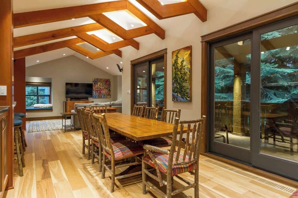 - Bright dining room with rustic wooden table and forest-view windows  
- Sliding doors open to a scenic deck for indoor-outdoor dining  
- Perfect for family meals surrounded by mountain charm and greenery 