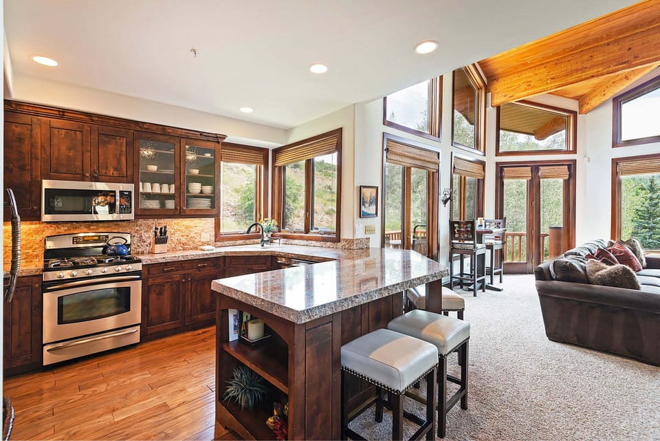 Fully Equipped Kitchen with Granite Countertops, Bar Seating for Four, Stainless Steel Appliances and Beautiful Hardwood Flooring