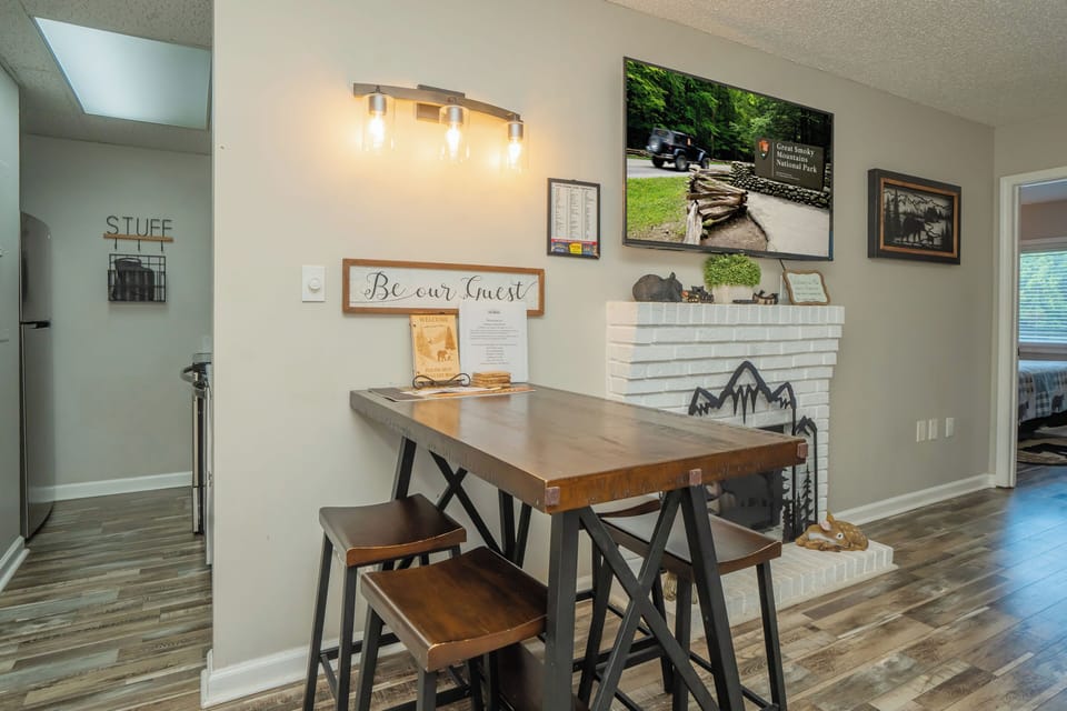 Gather around your welcoming dining space, thoughtfully styled with rustic touches and mountain-inspired decor. A skylight overhead bathes the room in natural light, creating the perfect spot for morning coffee or evening meals together.