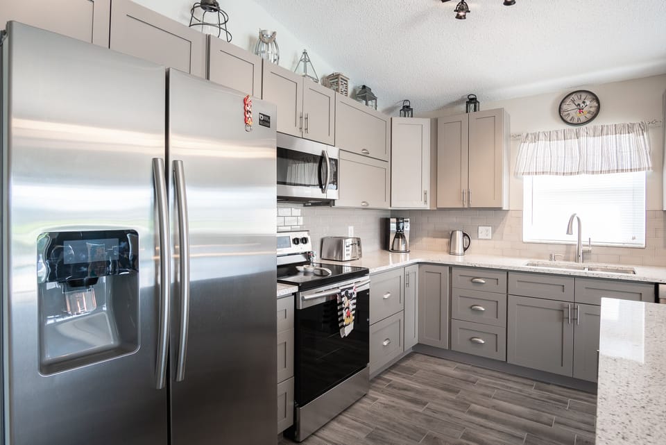 Modern kitchen with stainless steel appliances and gray cabinetry.