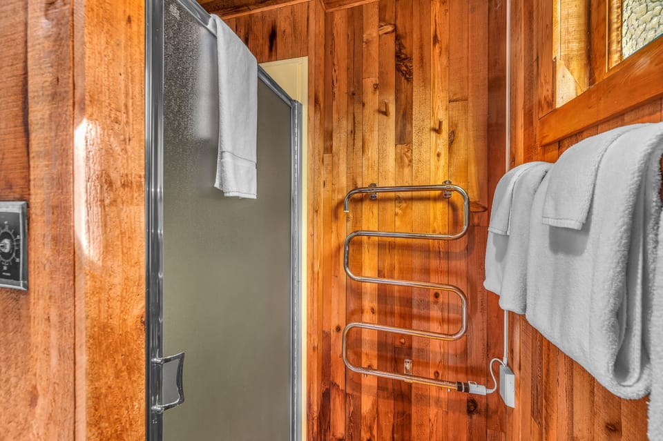 Step into your cozy bathroom where warm cedar walls create a spa-like retreat, complete with fresh towels and modern amenities.