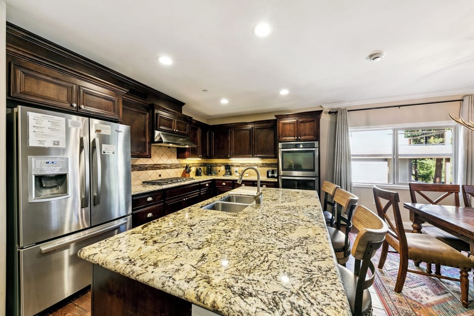Your gourmet kitchen features rich wood cabinets, granite countertops, and stainless steel appliances—perfect for creating memorable meals together.