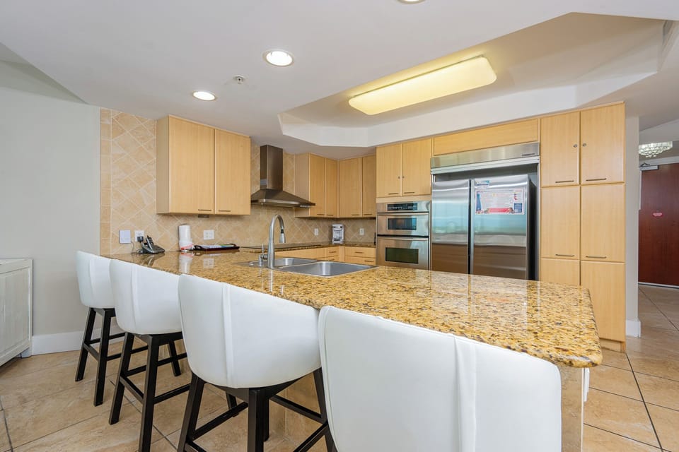 Sleek and modern kitchen featuring sleek stainless appliances and a spacious granite countertop with stylish seating