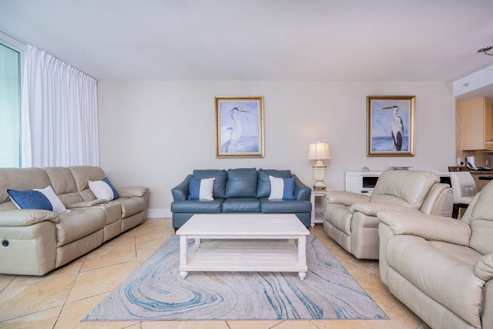 Inviting living area featuring plush seating, coastal artwork, and a light, airy atmosphere