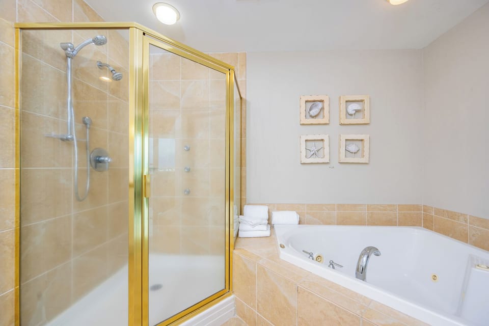 Relax in this elegant bathroom featuring a jetted tub, walk-in shower, and coastal-inspired decor for a refreshing retreat