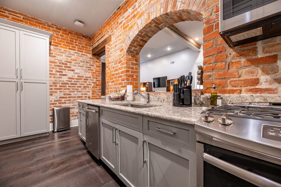 Galley-style, fully equipped kitchen with an open flow to the living/dining area. Stocked with essentials from mixing bowls to wine glasses, featuring stainless steel appliances, stone countertops, and a tile backsplash for a luxurious feel!