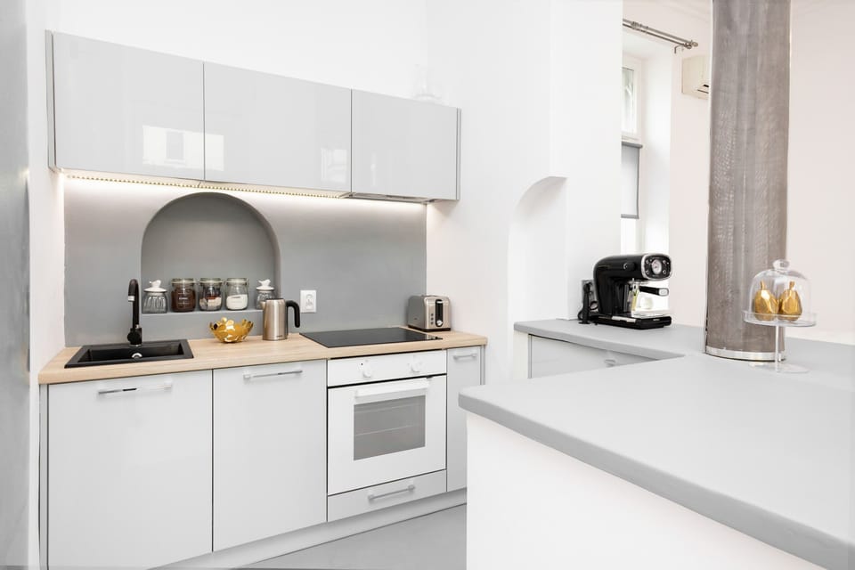 Bright and functional kitchenette with an oven, a coffee machine, and an electric kettle.
