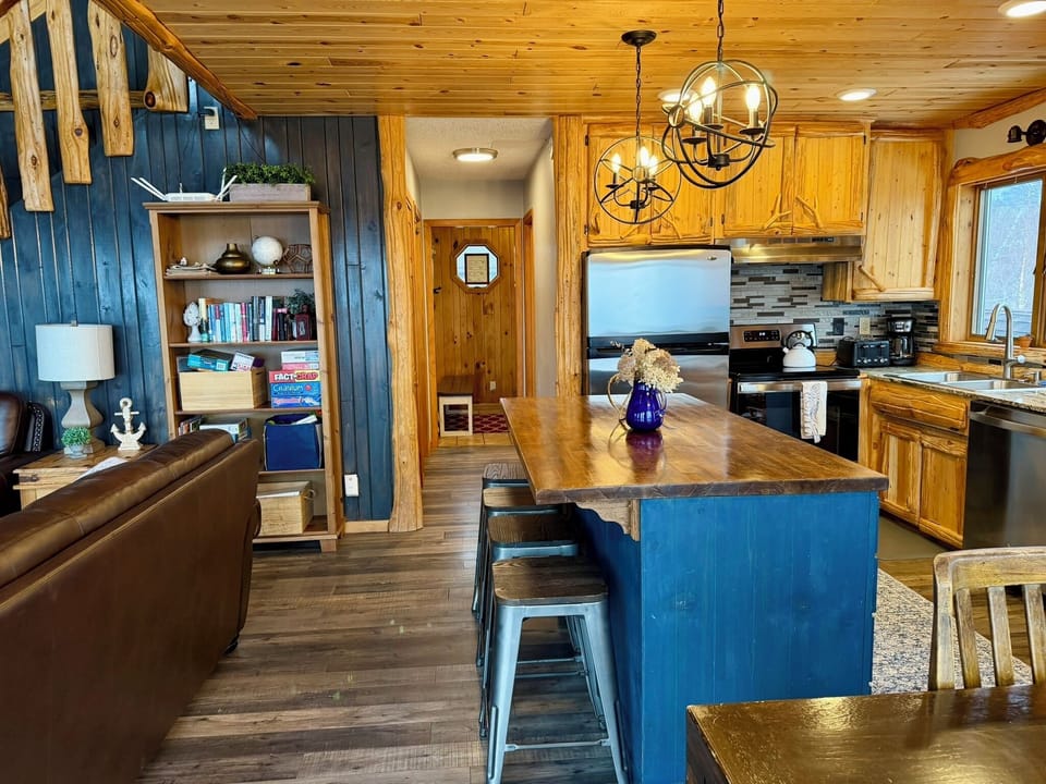 Step back in from the deck to a cozy hangout, with board games on the  shelf ready to play, the kitchen right there, and a warm, fun space to relax and reconnect after a day exploring the North Shore.