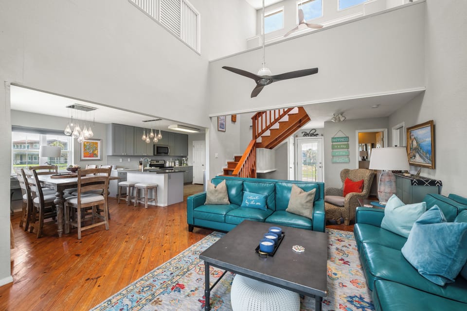 Unwind in your open-concept living area with soaring ceilings and rich wood floors. Sink into plush seating, prepare meals in the modern kitchen, and enjoy the light-filled space perfect for gathering with loved ones.