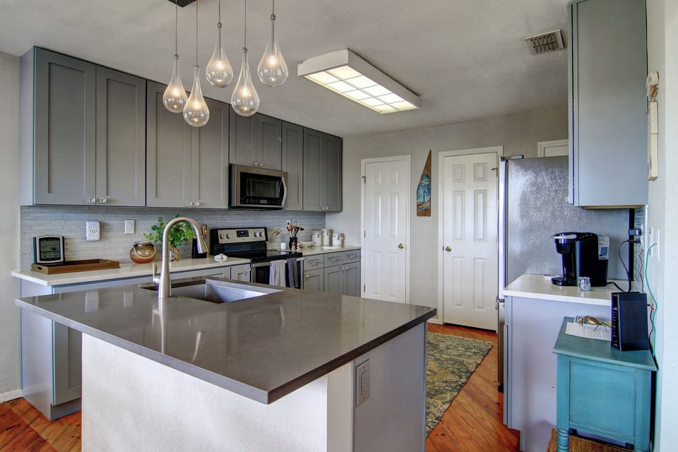 Cook memorable meals in your fully equipped modern kitchen with sleek pendant lighting and spacious granite island for prep.