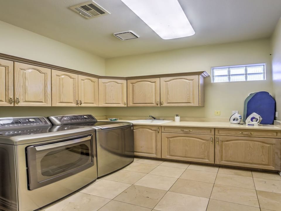 Nice size laundry room with rions and ironing boards
